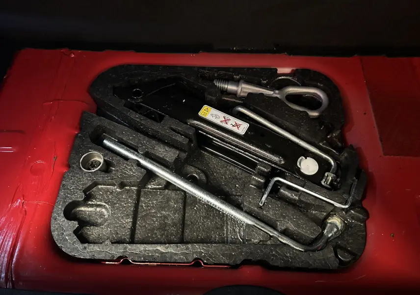 Coffre ouvert vu de l'arrière d'une MINI Cabriolet Cooper S rouge de 2012 avec capote noire.