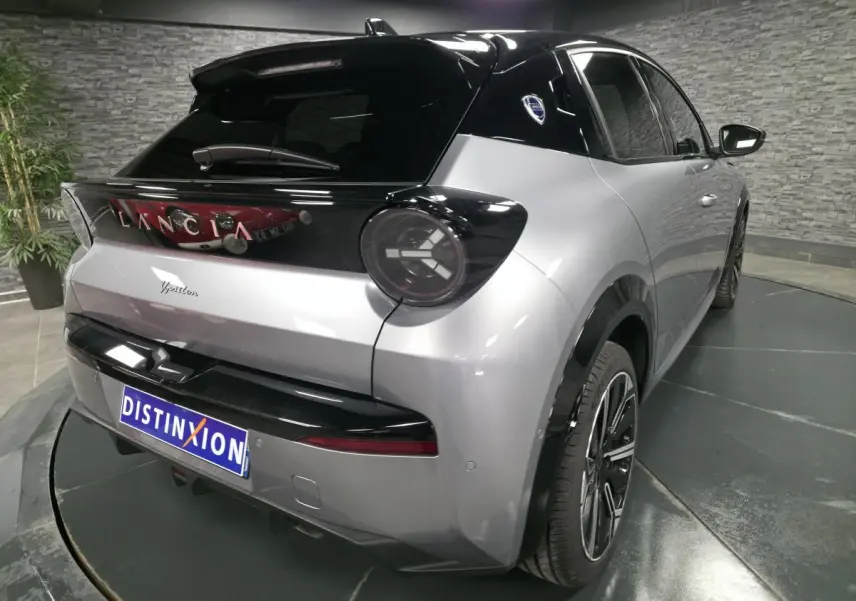 Vue 3/4 arrière droite de la Lancia Ypsilon 2025 gris bi-color avec toit noir et jantes alliage 17 pouces diamantées.