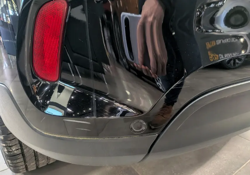 Gros plan sur le coin arrière droit noir cinéma du FIAT 500X 2024, avec feu rouge et capteur de recul visible.