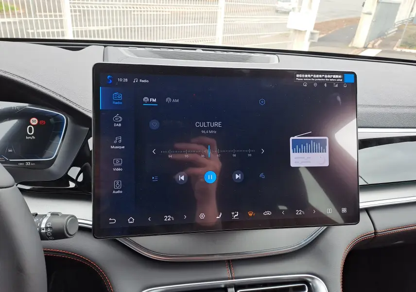 Vue intérieure frontale du tableau de bord BYD SEAL U 2025 avec écran tactile central 15,6'' et finitions noires avec surpiqûres orange.