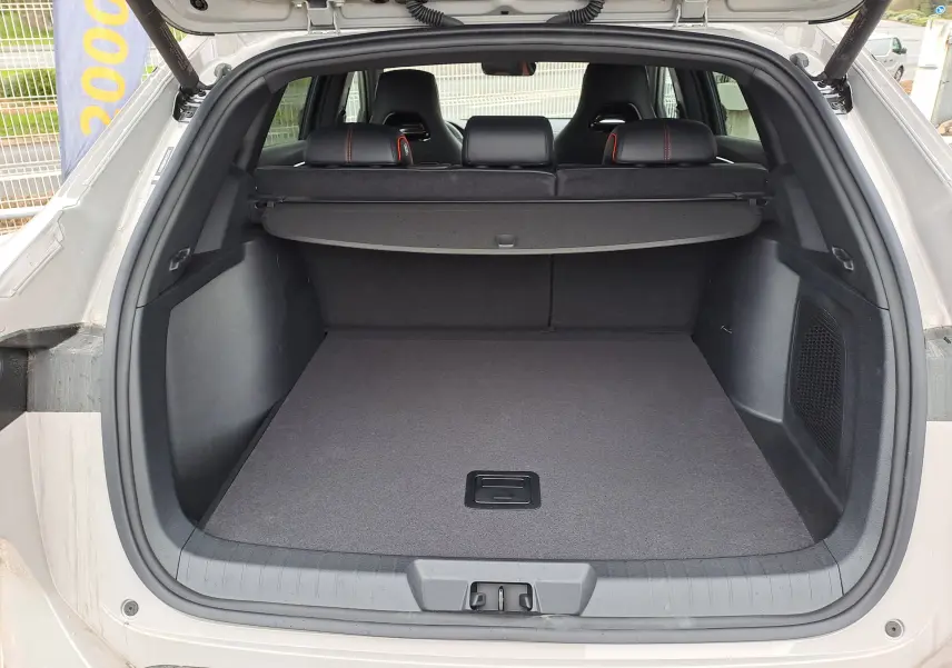 Détail intérieur côté conducteur du tableau de bord noir avec surpiqûres rouges et commandes sous volant du BYD SEAL U.