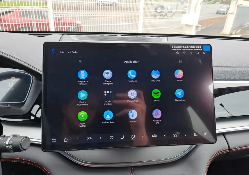 Vue intérieure centrée sur la console centrale et les sièges avant en similicuir marron avec surpiqûres rouges du BYD SEAL U.