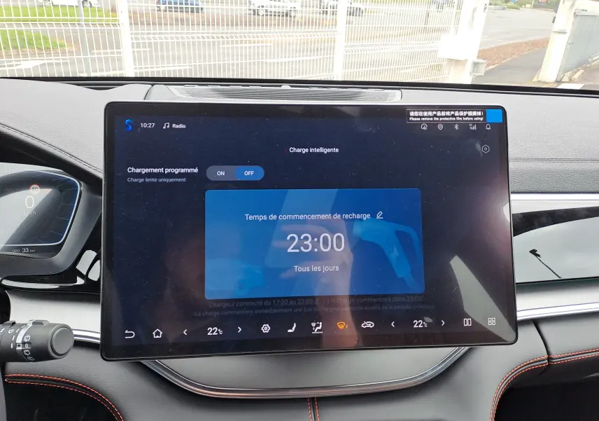 Vue plongeante sur la console centrale ouverte du BYD SEAL U 2025, avec accoudoirs noirs et sièges marron clair à surpiqûres orange.