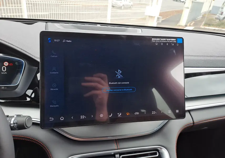 Vue plongeante sur la console centrale argentée du BYD SEAL U avec sièges marron et surpiqûres orange visibles.