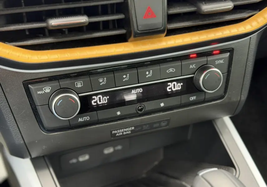Détail de la console centrale du SEAT Arona TSI 115 DSG Style 2025, montrant la climatisation automatique bi-zone à 20°C.