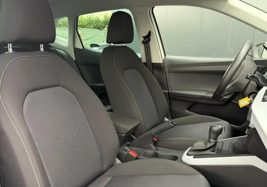 Vue intérieure côté droit du SEAT Arona 2025, sièges tissu gris et console centrale avec boîte automatique.