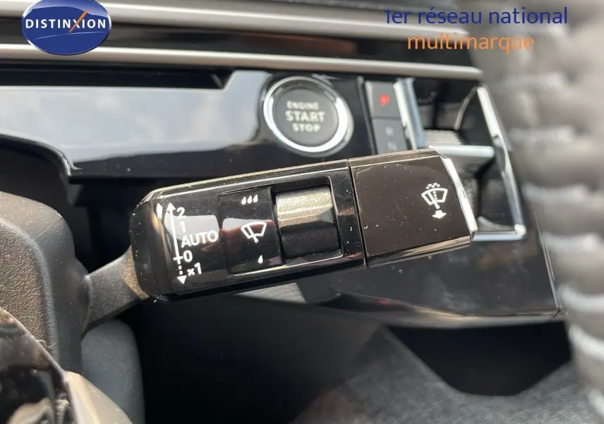 Gros plan sur la commande d’essuie-glace et le bouton start/stop du tableau de bord d’un Peugeot 3008 gris Artense 2025.