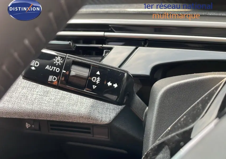 Gros plan sur la commande des feux et clignotants à gauche du volant dans l’habitacle du Peugeot 3008 gris Artense.