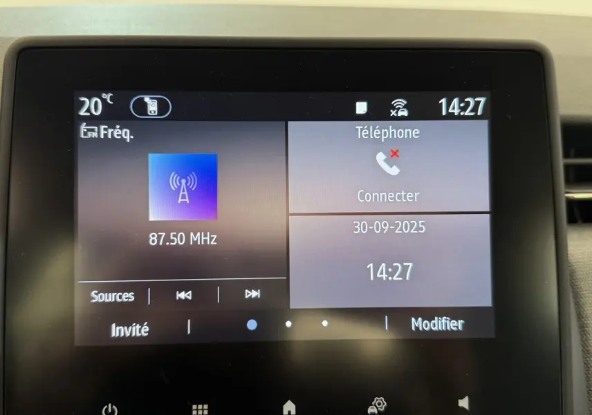 Écran tactile central de la Renault Clio noire 2025 affichant radio FM et menu téléphone à 14h27.
