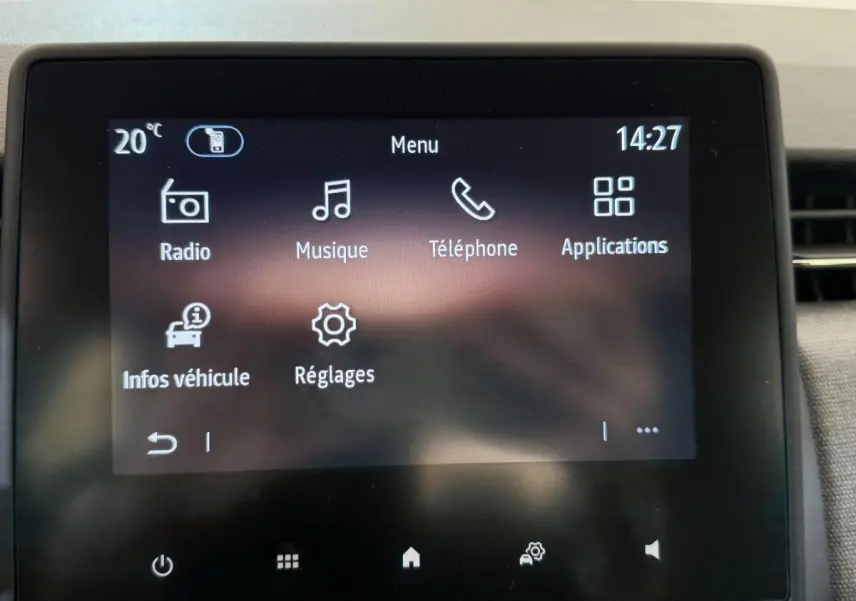 Écran tactile central de la Renault Clio noir 2025 affichant menu radio, musique, téléphone et applications.