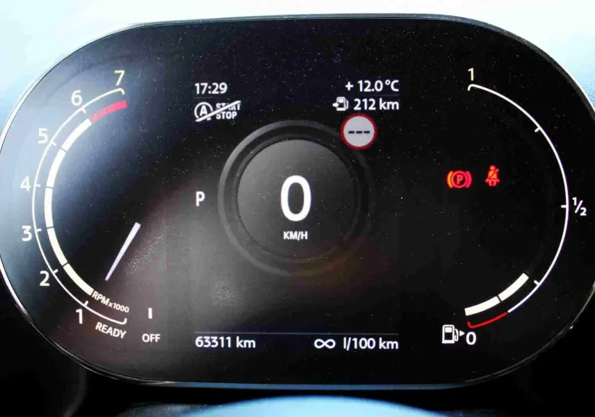 Vue rapprochée du tableau de bord numérique du MINI Countryman gris perle, affichant la vitesse à zéro et divers indicateurs.