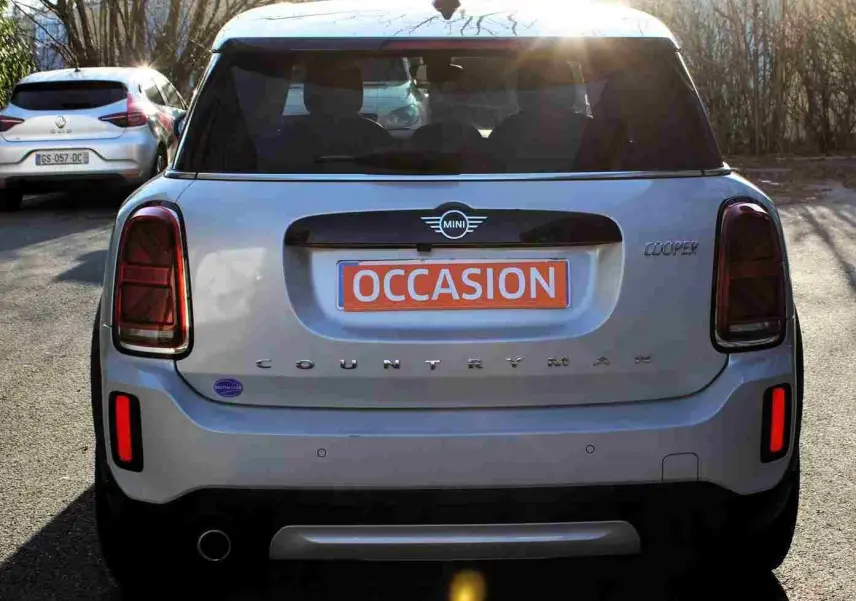 Vue arrière d'une MINI Countryman gris perle métal avec toit noir, feux arrière foncés et plaque "OCCASION" orange.