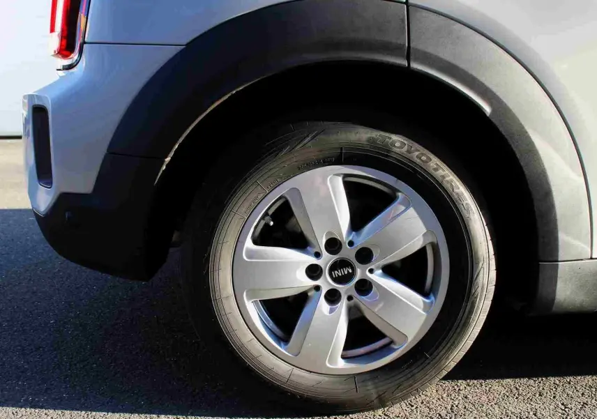 Gros plan sur la roue arrière droite d'une MINI Countryman gris perle métal avec jante alu cinq branches.