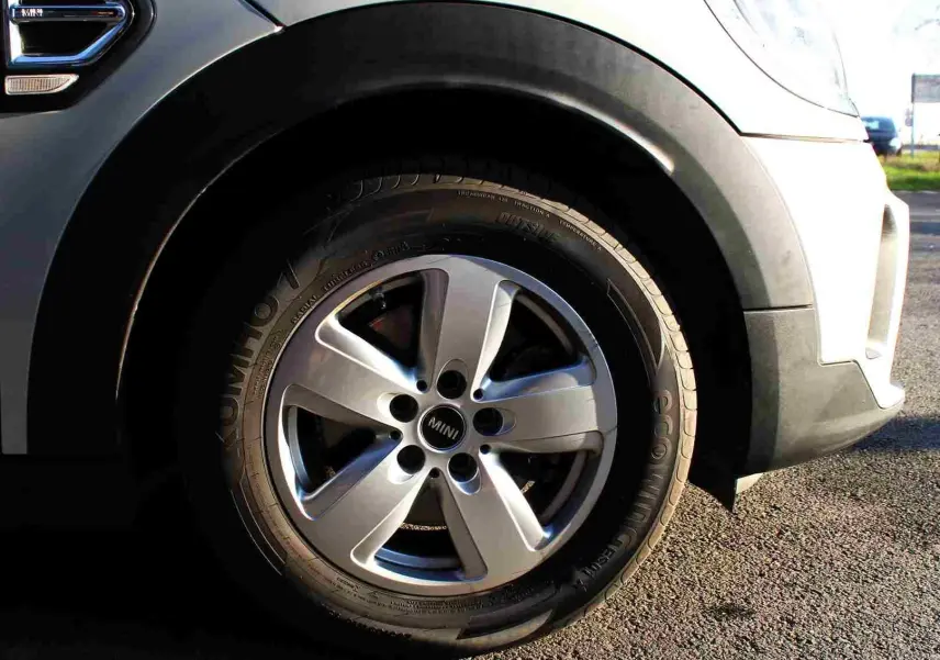 Gros plan sur la roue avant droite d’un MINI Countryman gris perle métal avec jante alliage cinq branches.