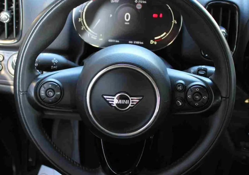 Vue rapprochée du volant en cuir noir de la MINI Countryman 2020 avec tableau de bord digital allumé.