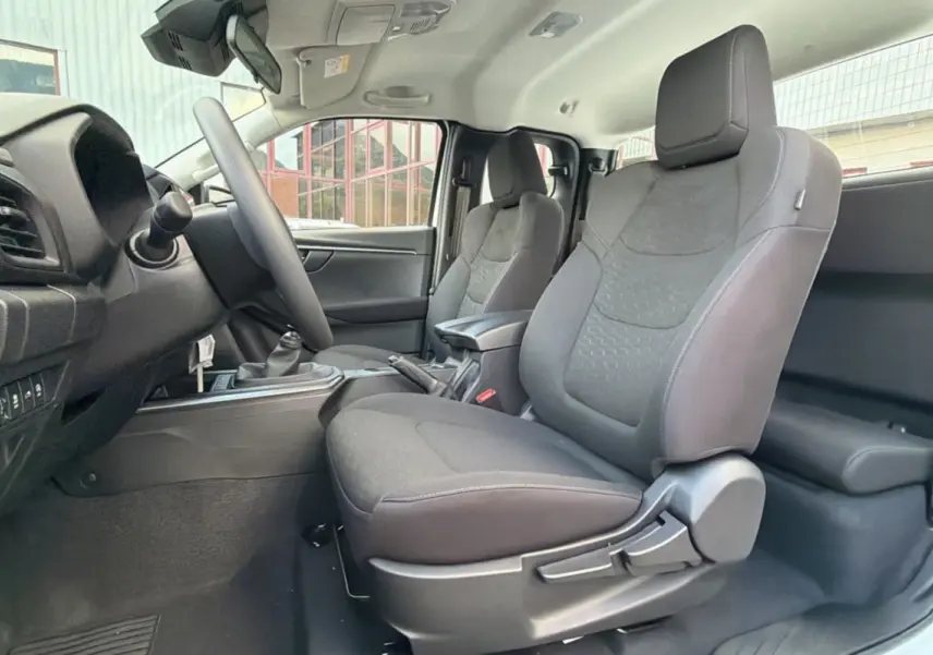 Vue intérieure côté gauche des sièges avant tissu gris foncé de l'Isuzu D-MAX 2026 avec accoudoir central.