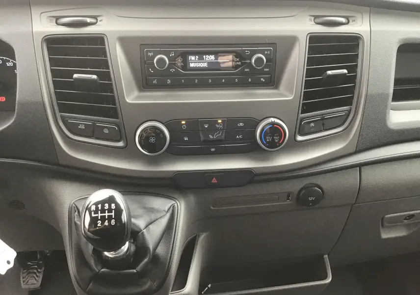 Vue rapprochée de la console centrale du Ford Transit Chassis Cabine 2024 avec boîte manuelle et commandes climatisation.