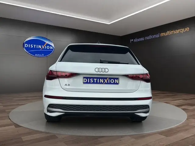 Vue arrière d'une Audi A3 Sportback 2024 en blanc Arkona, avec feux LED et logo Audi bien visibles.