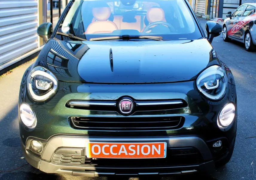 Vue de face d'une FIAT 500X vert Toscane métallisé avec intérieur cuir marron et plaque "OCCASION" visible.