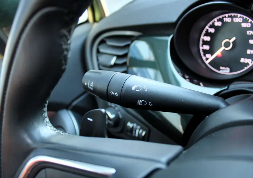 Gros plan sur la manette des feux et clignotants côté gauche du volant d'une Fiat 500X 2019, tableau de bord visible.
