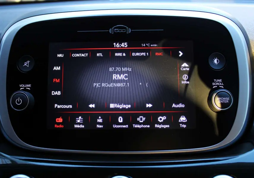 Écran tactile central du tableau de bord de la Fiat 500X affichant la radio RMC en mode FM, avec commandes autour.
