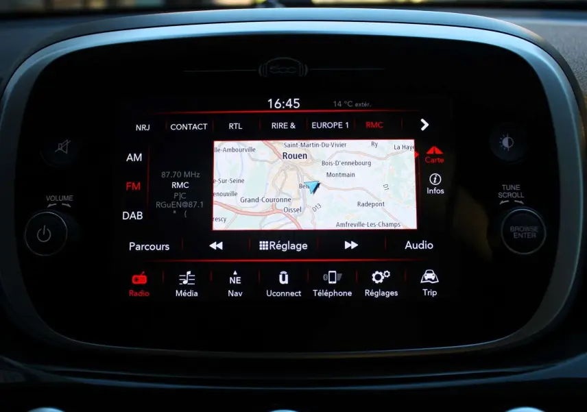 Écran tactile central de la Fiat 500X affichant la navigation et la radio, avec commandes autour en noir brillant.