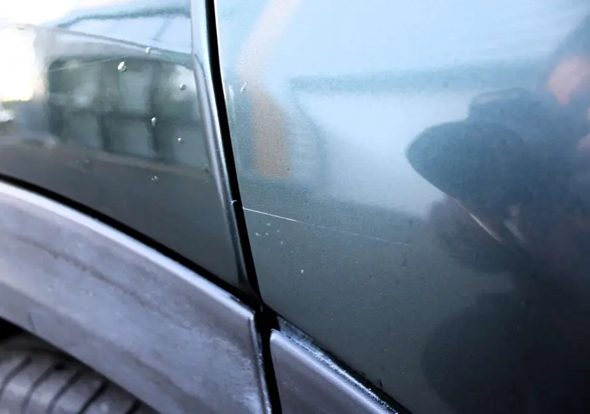Gros plan sur la portière arrière droite vert Toscane métallisé du Fiat 500X avec rayure visible près du passage de roue.