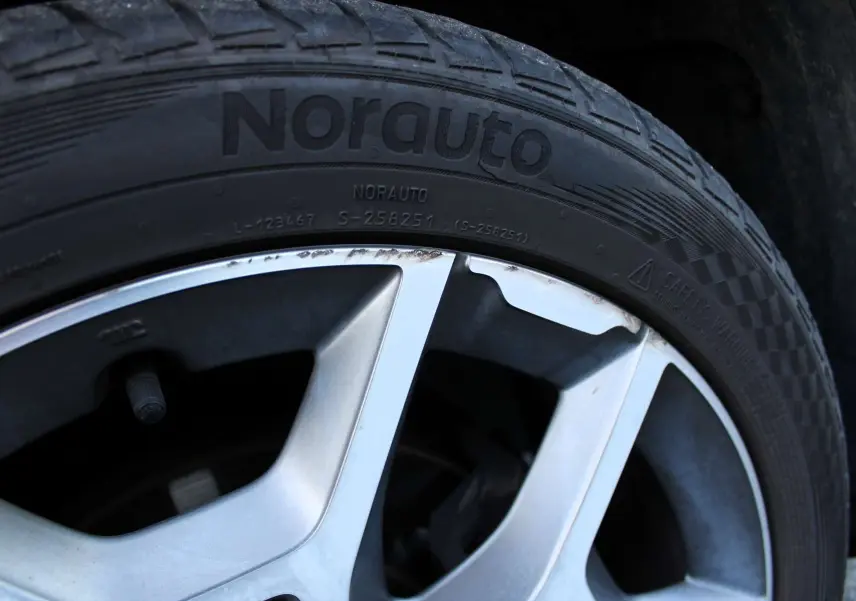 Gros plan sur la jante alliage biton et pneu Norauto du FIAT 500X vert Toscane métal de 2019.