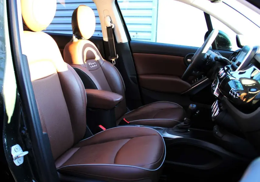 Intérieur avant droit du FIAT 500X 2019 avec sièges en cuir marron et tableau de bord noir brillant.