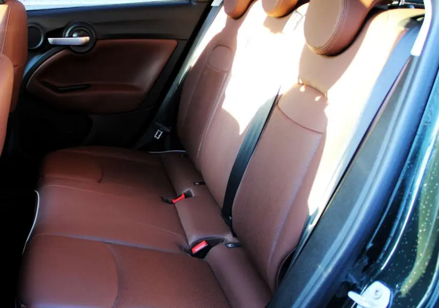 Vue intérieure côté droit des sièges arrière en cuir marron d'une FIAT 500X 2019 vert Toscane métallisé.