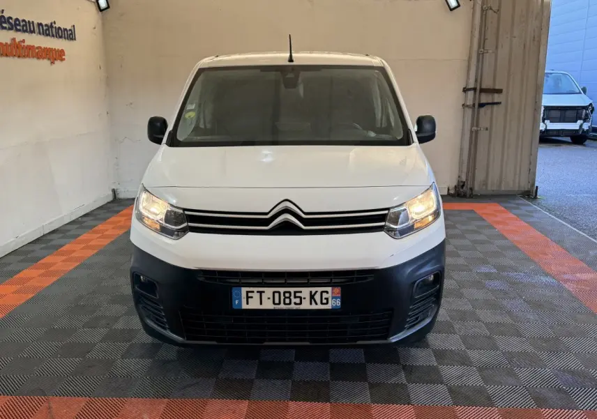 Vue de face du Citroën Berlingo blanc 2020 avec phares allumés et pare-chocs noir dans un garage.