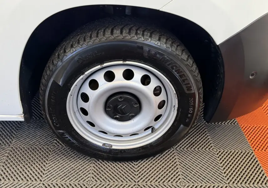 Gros plan sur la roue arrière droite en jante acier argentée du Citroën Berlingo blanc, avec pneu Michelin visible.