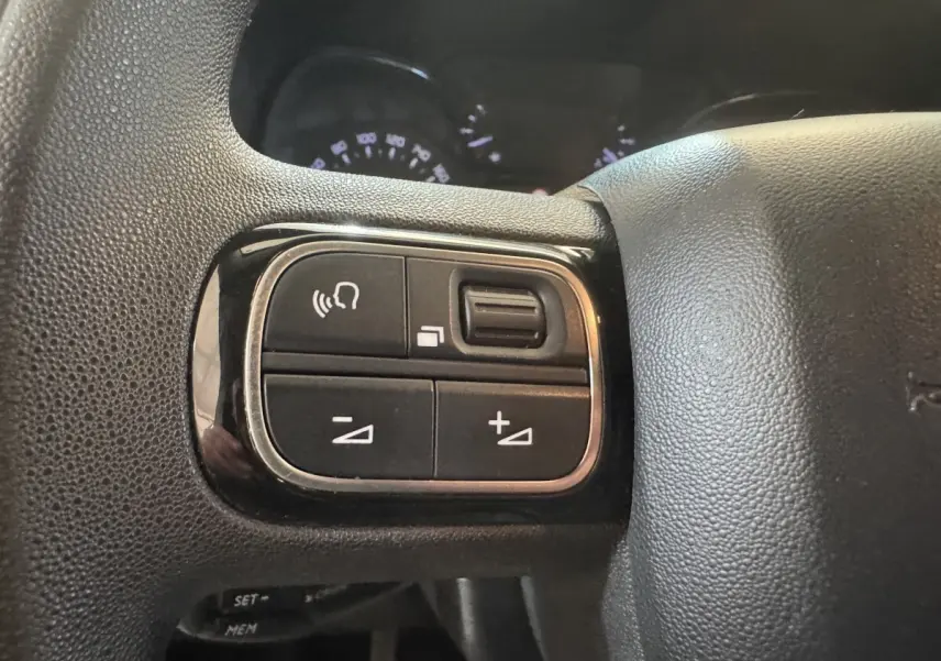 Gros plan sur les commandes multifonctions noires du volant du Citroën Berlingo blanc, version 2020.