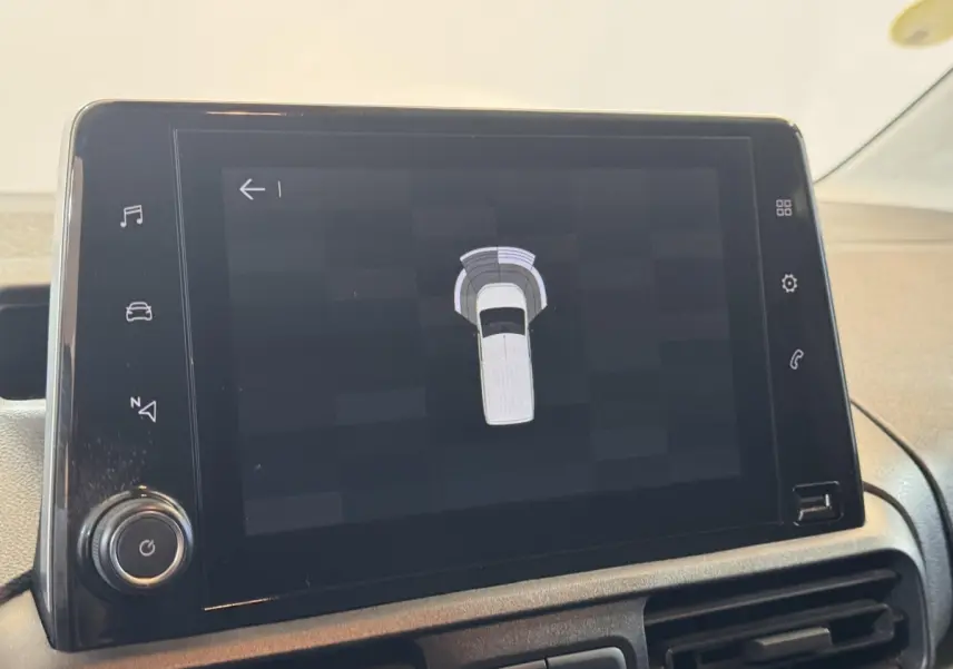 Écran tactile central affichant l'aide au stationnement du Citroën Berlingo blanc, vue intérieure du tableau de bord.