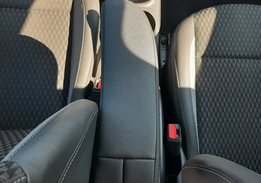 Vue plongeante sur l'accoudoir central noir et les sièges tissu gris à motifs de l'Opel Crossland X 130ch Innovation 2019.