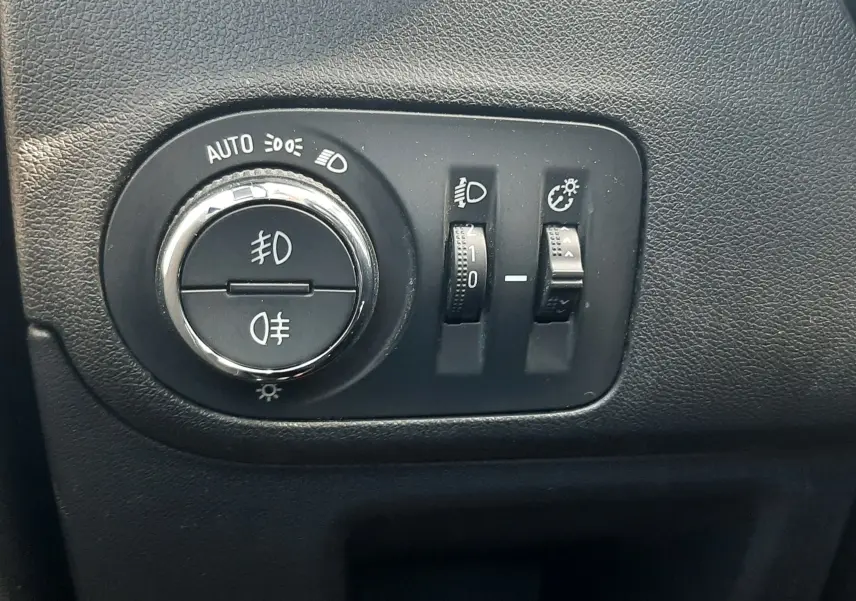 Gros plan sur les commandes d'éclairage noires de l'Opel Crossland X 130ch Innovation 2019, intérieur gris.