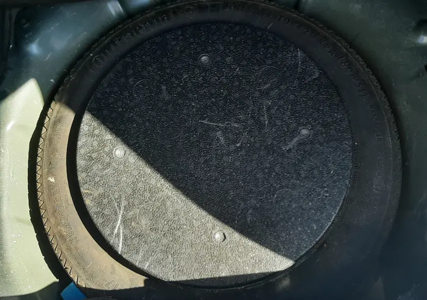 Pneu de secours noir en position verticale dans le coffre d'une Opel Crossland X 130ch Innovation 2019 noir toit blanc