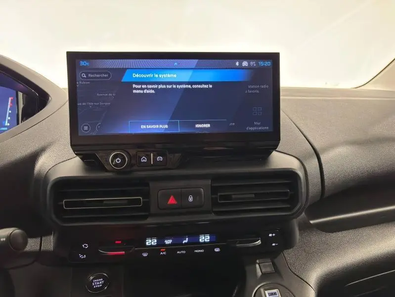 Tableau de bord noir du Peugeot Partner XL 2025 avec écran tactile central et commandes de climatisation digitales.