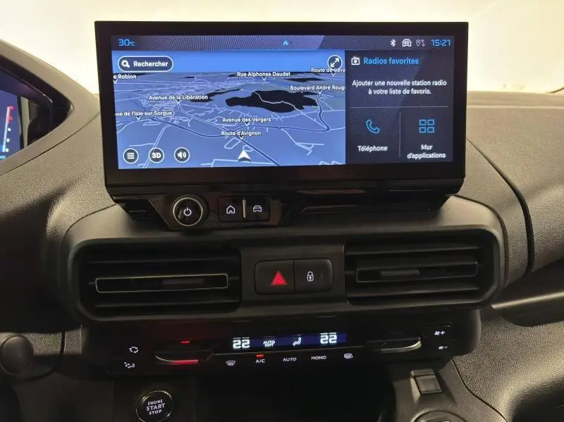 Tableau de bord du Peugeot Partner XL 2025 avec écran tactile affichant la navigation et commandes de climatisation numériques.