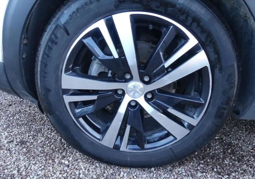 Gros plan sur la jante alliage bi-ton diamantée 18 pouces du Peugeot 3008 blanc nacré, version GT Line.