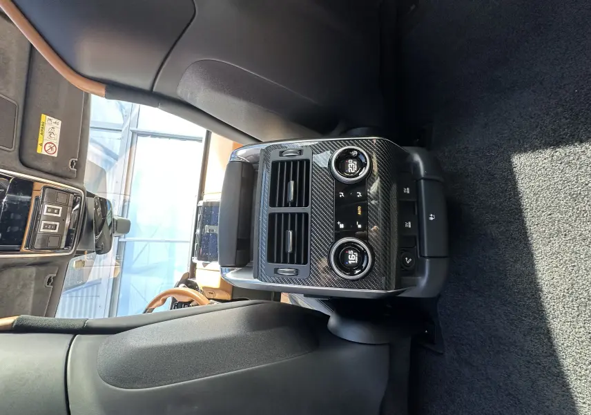 Détail de la console arrière en carbone avec commandes de climatisation et sièges chauffants du Range Rover Sport gris foncé 2020.