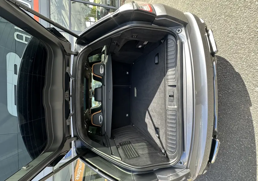 Coffre ouvert vu de l'arrière d'un Range Rover Sport gris foncé 2020, intérieur spacieux avec sièges arrière visibles.