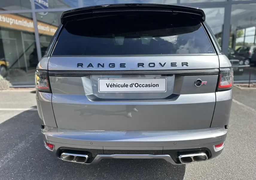 Vue arrière d'un Range Rover Sport gris foncé avec double sortie d'échappement et logo SVR rouge visible.
