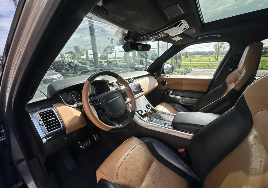 Intérieur du Range Rover Sport SVR 2020 en gris foncé, vue côté conducteur montrant cuir beige et tableau de bord moderne.