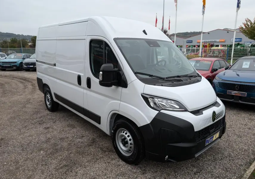 Vue 3/4 avant droite d'un utilitaire Citroën Jumper blanc avec pare-chocs noir et jantes acier 16 pouces.