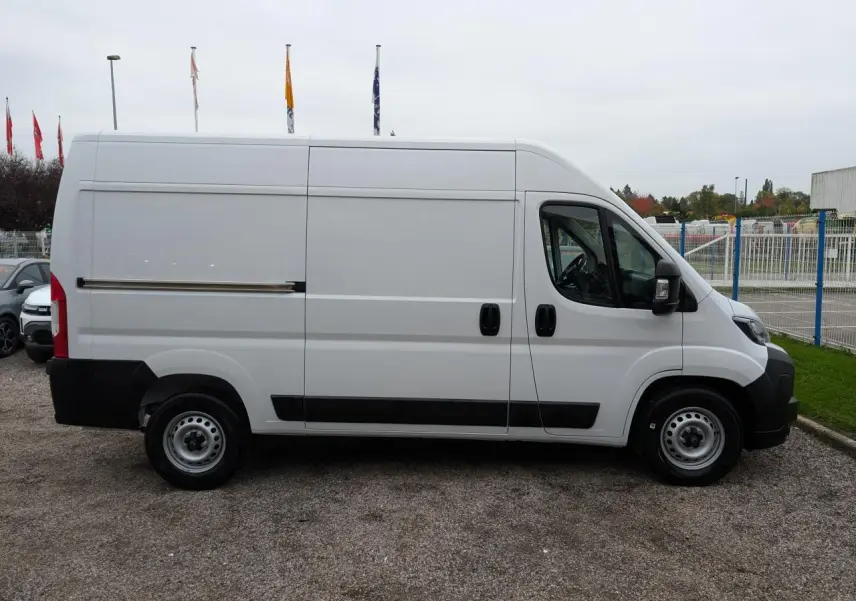 Profil latéral droit d'un utilitaire Citroën Jumper blanc avec porte coulissante et roues acier 16 pouces.