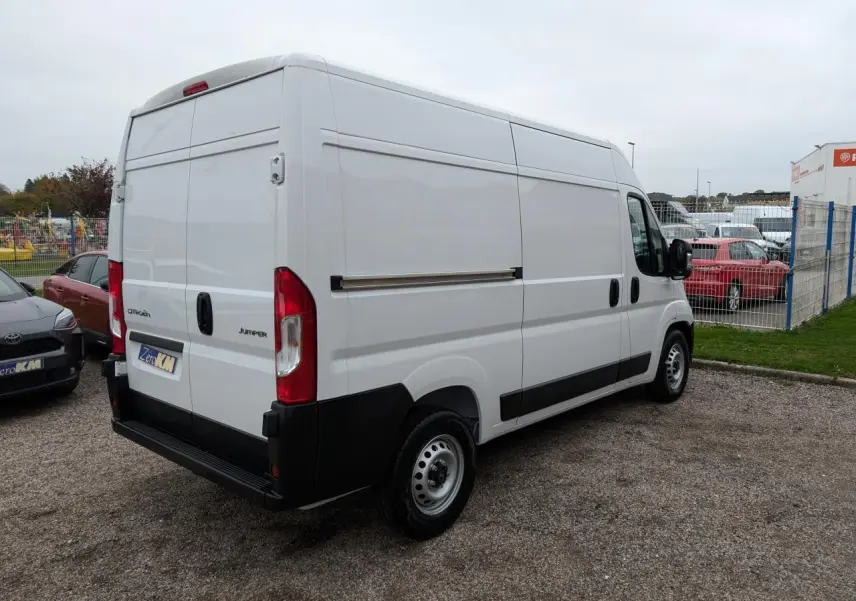 Vue 3/4 arrière droite du Citroën Jumper blanc 2025 avec portes arrière battantes et roues acier 16 pouces.