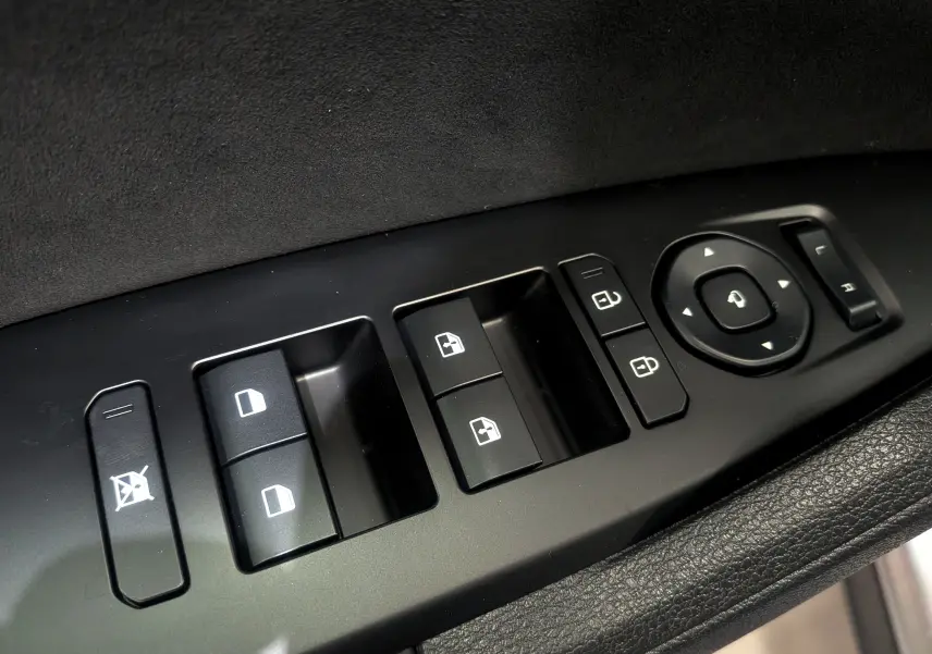 Panneau de commandes des vitres et rétroviseurs côté conducteur du Kia Sportage 2025 gris céramique toit noir.