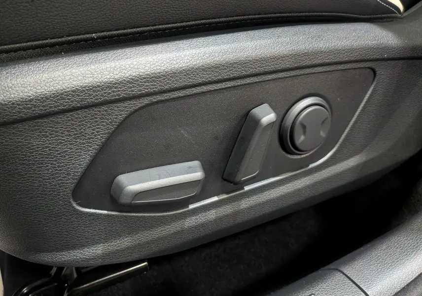 Gros plan sur les commandes de réglage électrique du siège conducteur du Kia Sportage gris céramique 2025.