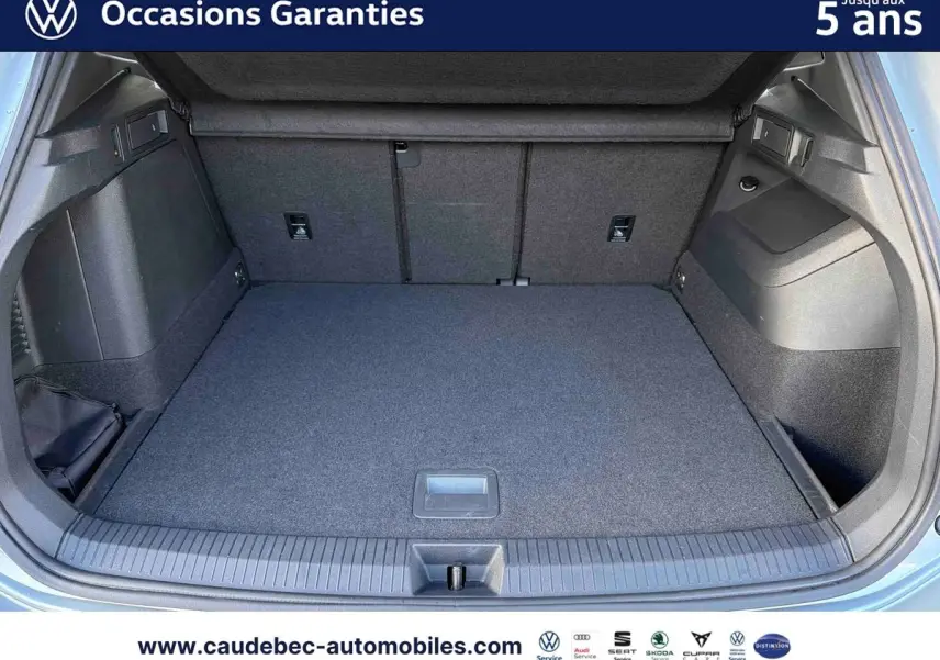Coffre ouvert d’un Volkswagen Tiguan argent Dolomite, vue de l’arrière montrant l’espace de chargement vide.